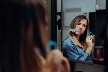 Woman Pulls Her Hair Putting on Curlers in the Bathroom. Lady trying a safer but painful heat less curling method at home