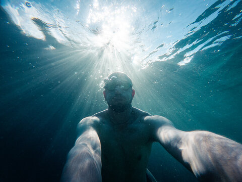 Underwater selfie in dramatic sunlight