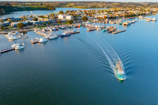 Fishing trawler leaving a harbor of boats