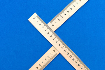 Wooden measuring rulers on blue background