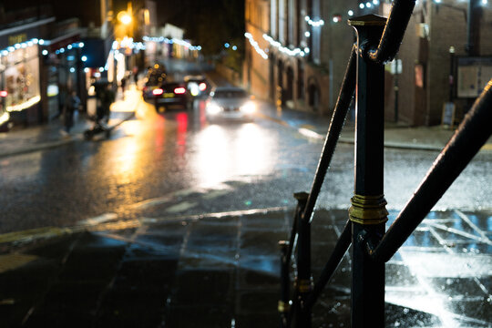 A quiet high street with shops on a rainy night