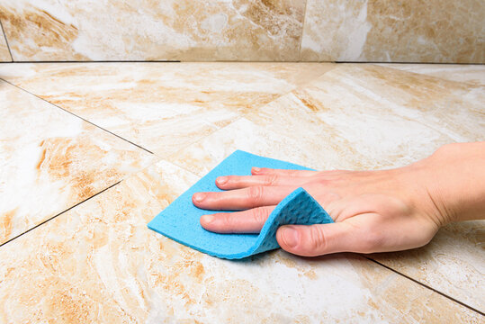 Worker washing tiles after jointing.