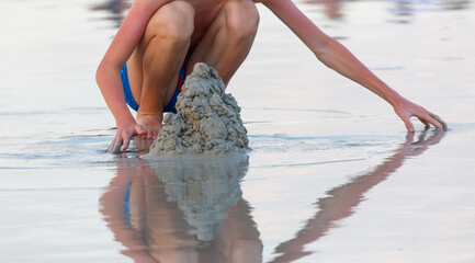 A boy is playing in the sand at the beach