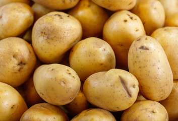 A pile of potatoes with some of them being cut in half