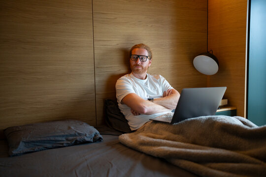 Man taking a thoughtful break from his laptop in a quiet modern room