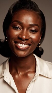 Portrait of a woman with radiant skin smiling brightly, wearing hoop earrings, and a white shirt