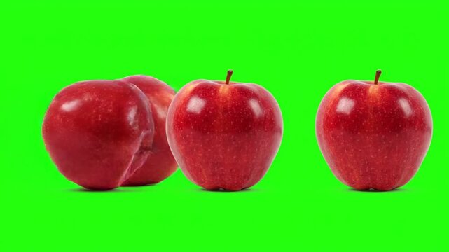 Three red apples on a green background