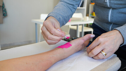 Physiotherapist prepares a hand brace for a young woman during rehabilitation session