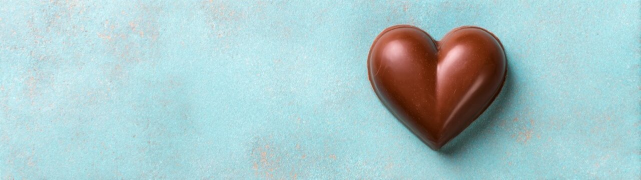 Chocolate heart on blue background sweet treat food photography romantic setting close-up view love concept