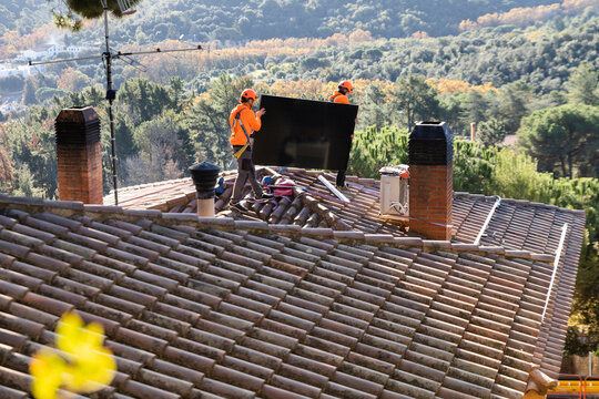 Solar panel installation by workers on rooftop in Barcelona outdoors