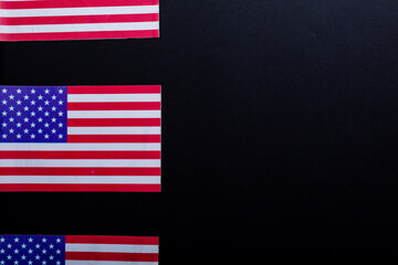 Row of usa flags with stars and stripes by copy space on black background