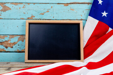 Blank writing slate with copy space by usa flag on blue wooden table