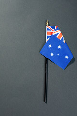 Overhead view of stars and union jack on australia flag stick by copy space over black table