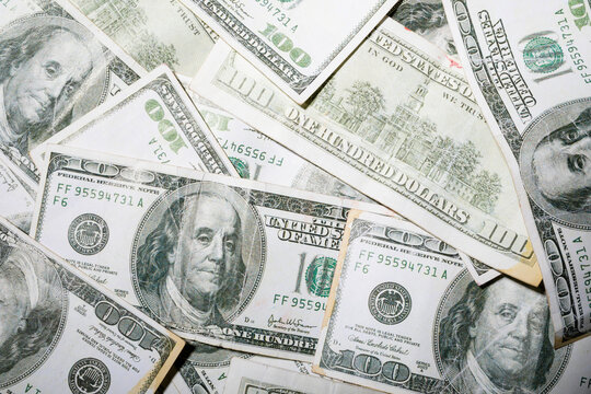 Full frame shot of scattered hundred dollar bills with famous historic personality