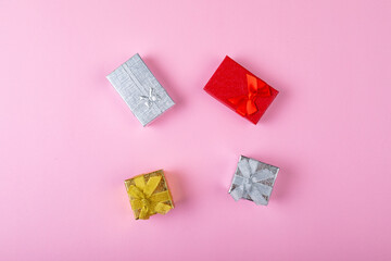 Overhead view of multi colored valentine present boxes on pink background with copy space