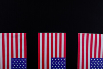 Usa flags with red and white stripes along with stars on black background with copy space
