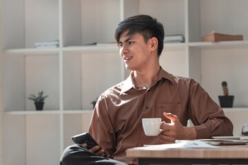 Young Man Enjoying Coffee While Using Mobile Phone in Cozy Space