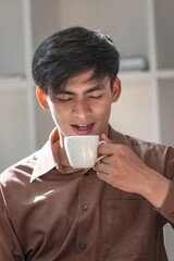 Young Man Enjoying Coffee in Modern Workspace Setting