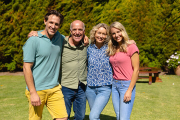 Fototapeta premium Portrait of caucasian two generation family smiling while standing together in the garden