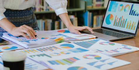Asian female accountant businesswoman analyze using laptop to collect financial data in office. Business finance, tax and accounting concept.