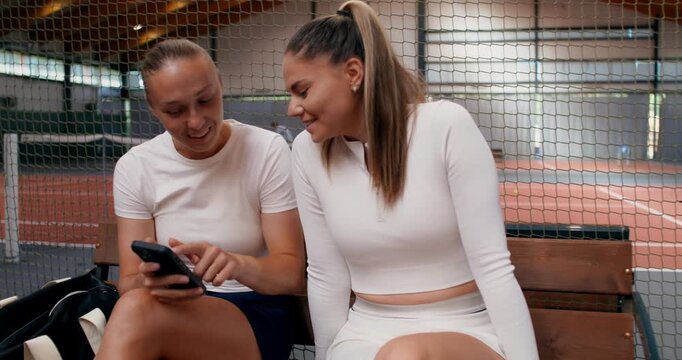 Close-up of female tennis players with cell phones in their hands.