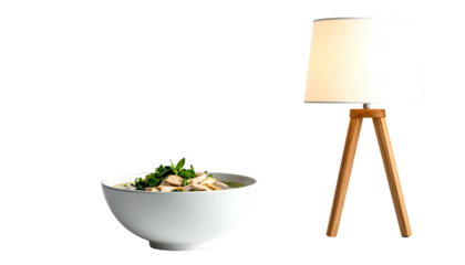 A bowl of steaming soup beside a minimalist lamp. The scene is isolated against a black background