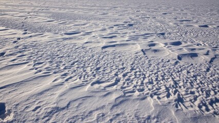 Snow covered landscape with textured terrain.