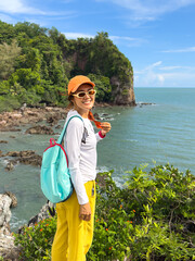Female tourist standing on coastal path in tropical nature