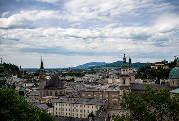 Obraz premium Panoramic view of Salzburg old town with historic churches and city skyline under cloudy sky