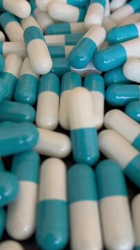 Blue and white medical capsules close-up pharmaceutical pills background texture