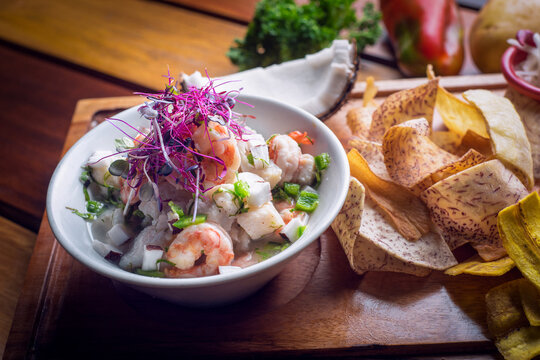 Shrimp ceviche with fried malanga and fresh coconut on wooden table
