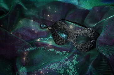 Venetian mask with gold decorations on a shiny background