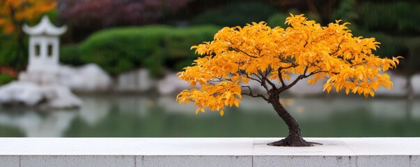 A vibrant bonsai tree with golden leaves stands before a serene pond, surrounded by lush greenery and traditional architecture, creating a peaceful scene.