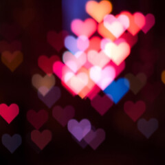 Vibrant and delicate heart shaped light bokeh with soft pink, blue, and purple glows, blending harmoniously to evoke a romantic and intimate mood, with gentle, feathery edges and a warm, ethereal