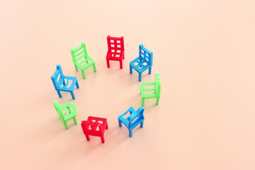 Concept image of circle of empty chairs on blue background