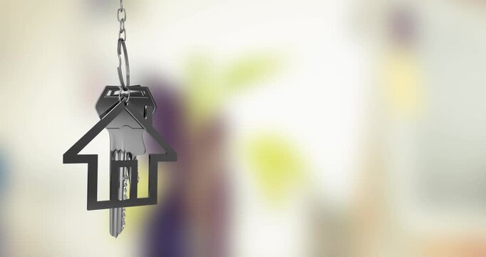 Animation of silver house key fob and key dangling over out of focus interiors with copy space