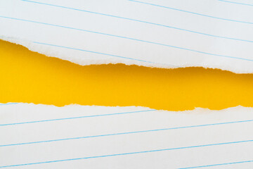 uneven torn white lined paper on grunge yellow paper, top view