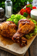 Roasted chicken drumsticks with mayonnaise on wooden table	