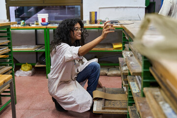Woman artist inspecting clay slab in studio
