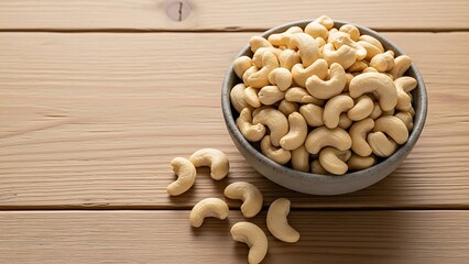 Healthy raw peanuts and cashews in a wooden spoon and bowl represent a natural organic snack and nutritious food ingredient isolated on a white background
