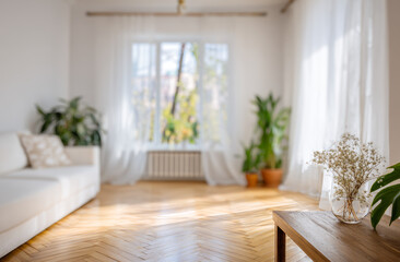 Fototapeta premium Bright and airy interior of a modern living room with large windows, white walls, wooden flooring, and lush green potted plants for a cozy and inviting ambiance