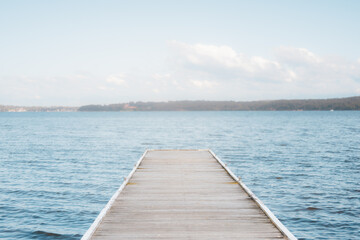 Empty wooden jetty leading out into peaceful lake