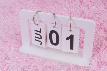 July 1 on calendar on pink carpet background