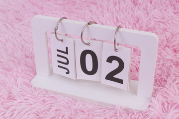 July 2 on calendar on pink carpet background