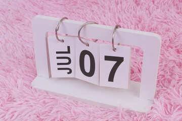 July 7 on calendar on pink carpet background