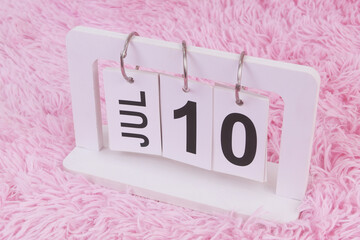 July 10 on calendar on pink carpet background