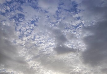 Photo of a high-angle shot of a sky featuring dappled altocumulus clouds. The soft blue and grey tones create a calming, natural pattern.