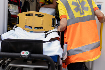 Paramedic preparing ambulance stretcher for emergency medical assistance
