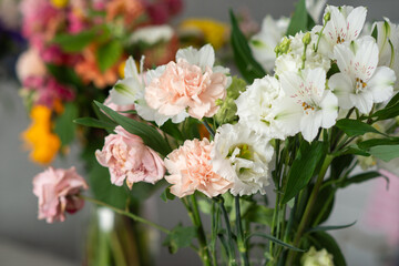 Colorful bouquet of pink carnations and white flowers with green stems