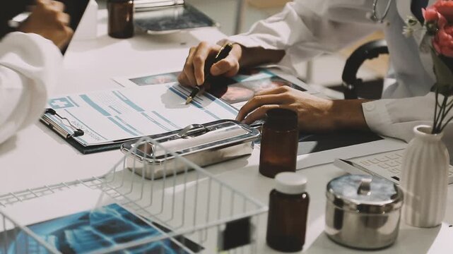 Medical team meeting analyzing blood test results in hospital laboratory. Doctors and scientists in lab coats are having a discussion about blood test result, holding test tubes and taking notes.
